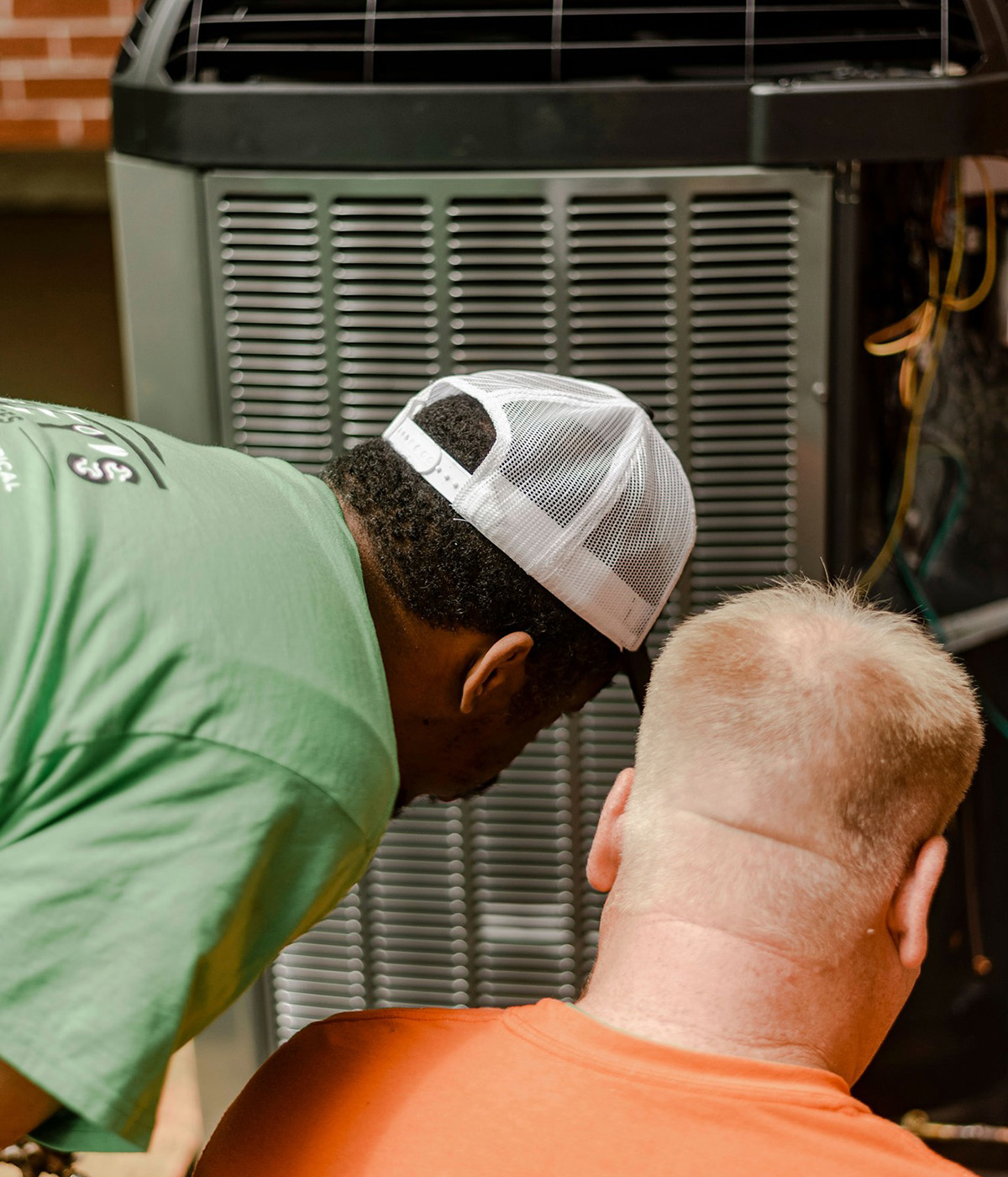Two Worleys technicians looking at trane unit