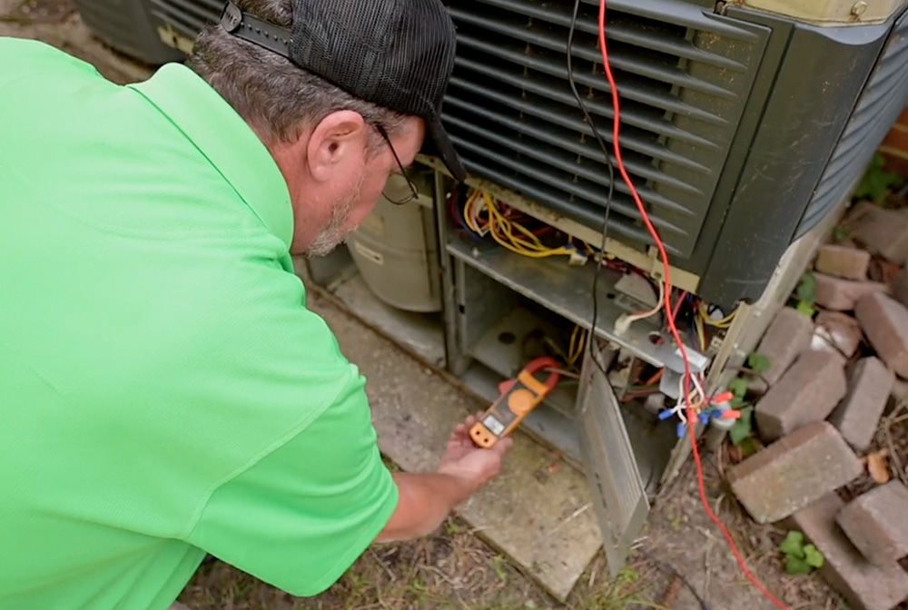 Worleys technician taking reading on AC unit