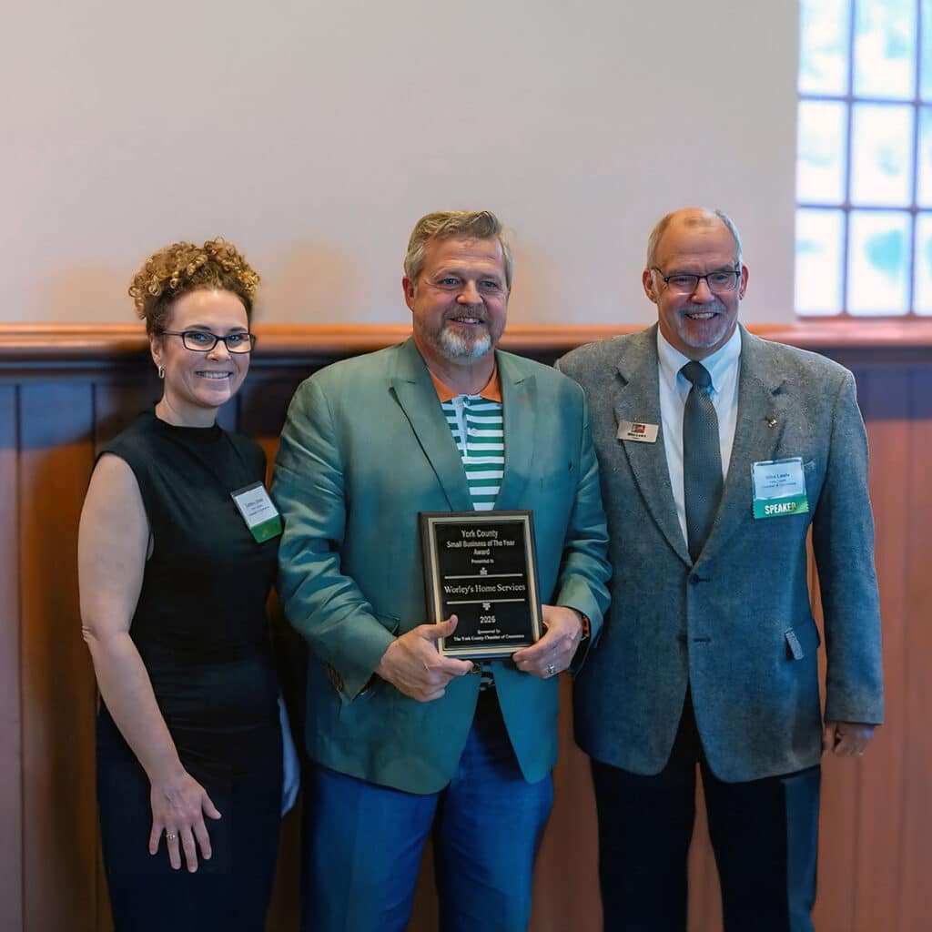 Worley's Home Services owner holding the York County Small Business of the Year 2026 award plaque, flanked by two Chamber of Commerce representatives at the awards ceremony.
