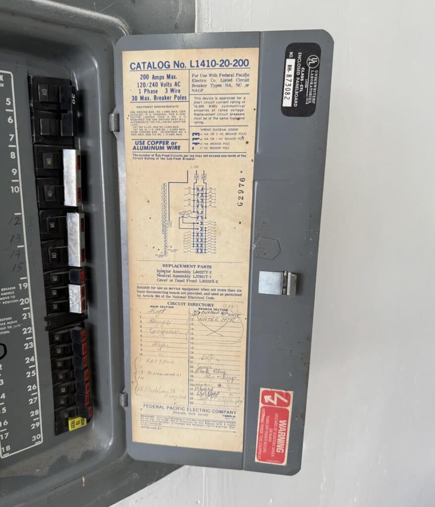 Open door of a 200-amp Federal Pacific panel reveals a faded wiring label and handwritten circuit directory.